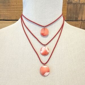 Bonni J triple strand coral colored shell necklace on coral cord